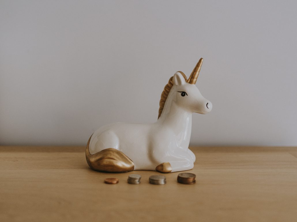 A wooden table with a ceramic unicorn.